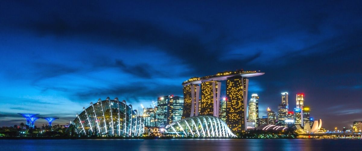 Travel to Singapore. Singapore also comes alive at night with neon colors as far as the eye can see